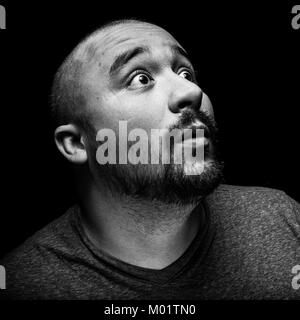 A high contrast black and white emotional and surprised portrait of a hispanic man. Stock Photo