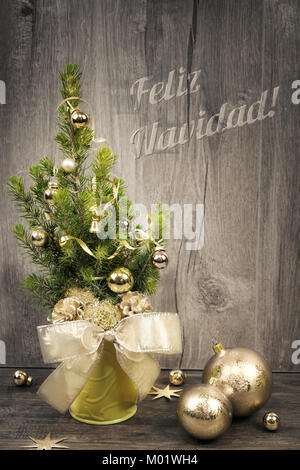 Greeting card with decorated Christmas tree and caption 'Feliz Navidad' or 'Merry Christmas' in burnt letters on wood Stock Photo