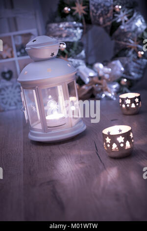 Decorative lantern, candles and Christmas decorations on vintage kitchen Stock Photo