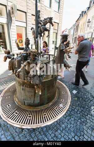 AACHEN, GERMANY - JUNE 27, 2010: people near Puppenbrunnen (Dolls fountain) on Kramerstrasse street in Aachen city in summer. Fountain was created in  Stock Photo