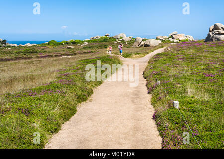 PERROS-GUIREC, FRANCE - JULY 3, 2010: tourists walk in natural park in Ploumanac'h site of Perros-Guirec commune on Pink Granite Coast of Cotes-d'Armo Stock Photo