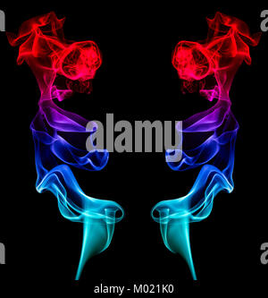 Two artistic mirror-image columns of red blue and green smoke providing a central black space for copy Stock Photo