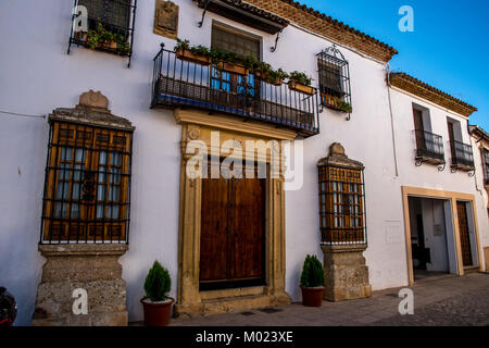RONDA, ANDALUSIA / SPAIN - OCTOBER 08 2017: WHITE HOUSE WITH METAL BALCONY AND WOODEN DOOR Stock Photo