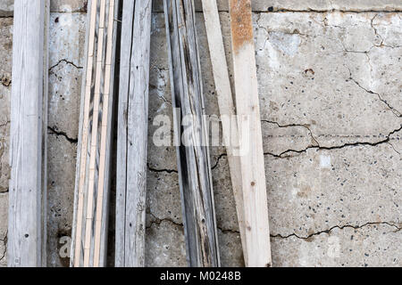 Wood leaning against weathered concrete wall; Chigocho, Izumo, Japan Stock Photo