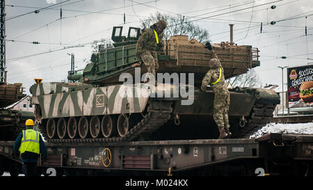 Soldiers assigned to 1st Battalion, 18th Infantry Regiment, 2nd Armored Brigade Combat Team, 1st Infantry Division, Fort Riley, Kansas, prepare a M1A2 Abrams to be off loaded from a rail car in Parsberg, Germany Jan. 17, 2018. Stock Photo