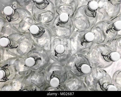 Transparent bottles seen from above. They can be filled with water, wine or other beverage. They are closed by a white plastic cap. Stock Photo