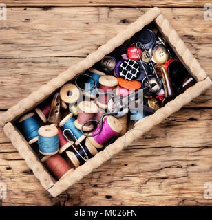 Wooden retro box, with thread spools and buttons. Sewing accessories. Stock Photo