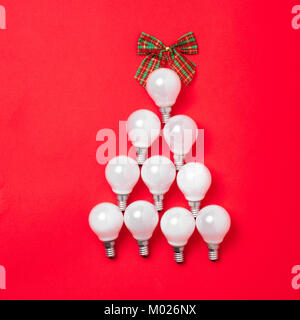 The christmas tree from lantern lamps laying on red background with copy space. Stock Photo
