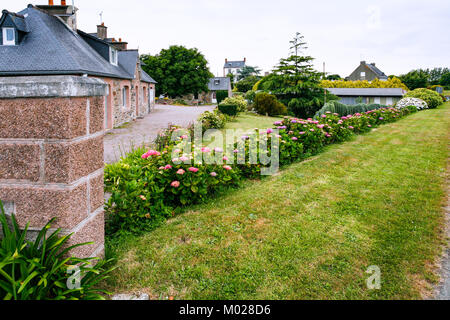 travel to France - street with flowerbed in Ploubazlanec commune of Paimpol region in Cotes-d'Armor department of Brittany in summer eveining Stock Photo