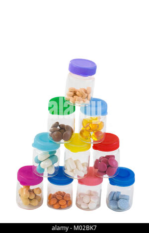 stack of Medicine Tablets in glass Box with multi colored plastic caps on white Stock Photo