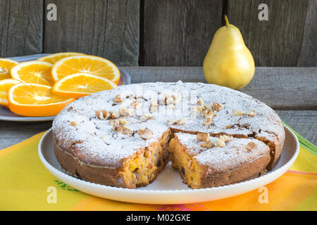 Delicious carrot cake with nuts and raisins on a white plate. Stock Photo