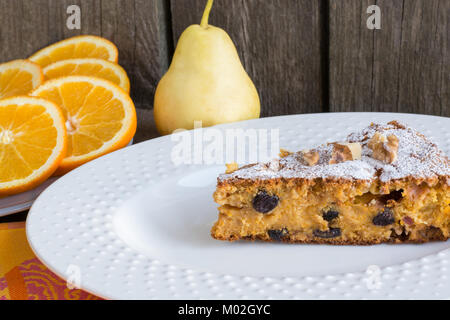 Delicious carrot cake with nuts and raisins on a white plate. Stock Photo