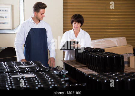 Workers counting number of wine bottles at sparkling wine factory Stock Photo