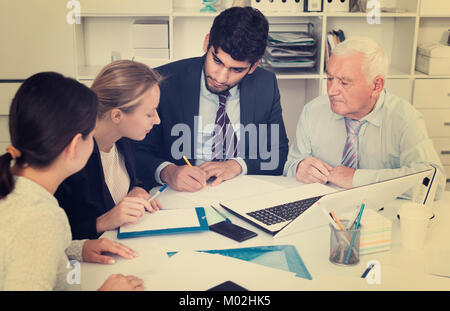 Managers are writing financial reports in the office. Stock Photo