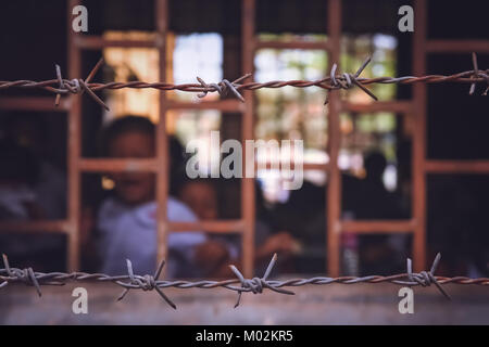 Barbed wire surrounding cambodian school based in the former prison, Phnom Penh, Cambodia Stock Photo