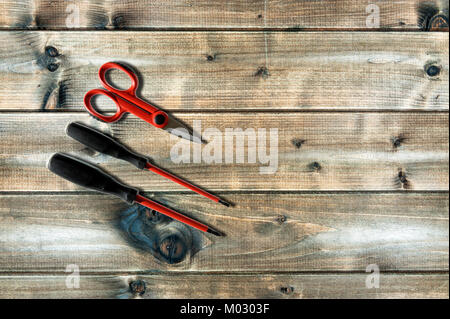 Scissors and screwdrivers for working on a residential electrical system photographed on an antique wooden desk. Stock Photo