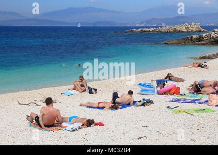 CORFU, GREECE - MAY 31, 2016: People enjoy the beach in Kassiopi, Corfu Island, Greece. 558,000 tourists visited Corfu in 2012. Stock Photo