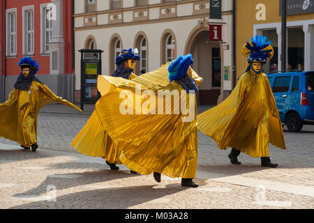 Four persons dressed in nice Venetian carnival costumes on Ash Wednesday in the city centre of Speyer, Germany. Stock Photo