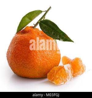 One and half segments of a mandarin next to whole mandarin with leaves isolated on white. Stock Photo