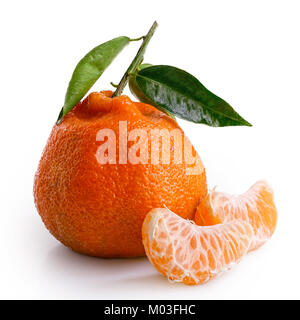 Two segments of a mandarin next to whole mandarin with leaves isolated on white. Stock Photo