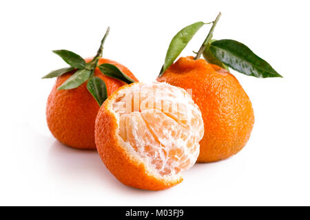 One half peeled and two whole mandarins with leaves isolated on white. Stock Photo