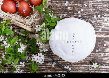 Blooming plum twig, Easter cake and  painted  eggs, spring composition on wooden table  viewed from above Stock Photo