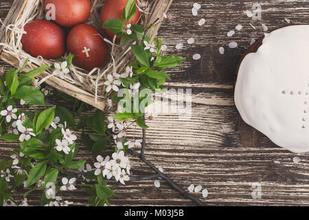 Blooming plum twig, Easter cake and  painted  eggs, spring composition on wooden table  viewed from above Stock Photo