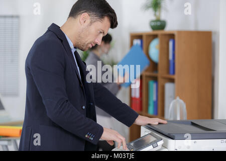 businessman using photocopy machine in office Stock Photo