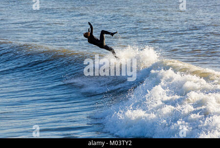 Bournemouth, Dorset, UK. 18th Jan, 2018. UK weather: after a very windy night a lovely sunny day at Bournemouth beach. Surfers make the most of the large waves and choppy seas.  Surfer riding a wave just about to fall. Credit: Carolyn Jenkins/Alamy Live News Credit: Carolyn Jenkins/Alamy Live News Stock Photo