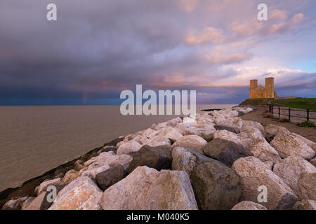 Bright light and dramatic pink and blue clouds over the twin towers of the Medieval church at Reculver, Kent, UK. Stock Photo