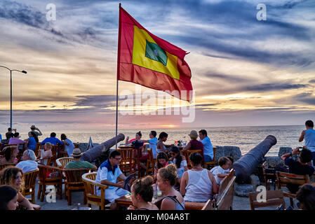 waving flag of Cartagena at sunset at Cafe del Mar Stock Photo