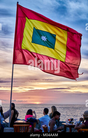 waving flag of Cartagena at sunset at Cafe del Mar Stock Photo