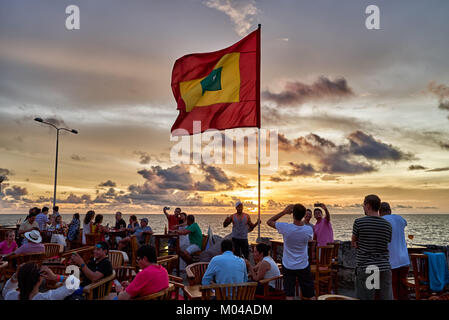 waving flag of Cartagena at sunset at Cafe del Mar Stock Photo