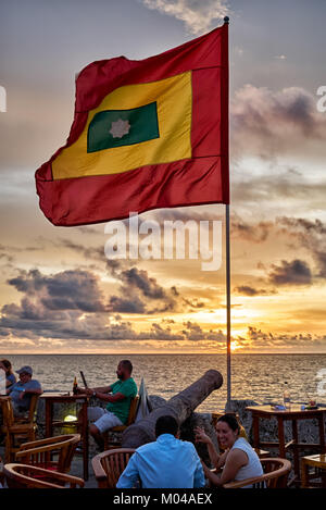 waving flag of Cartagena at sunset at Cafe del Mar Stock Photo