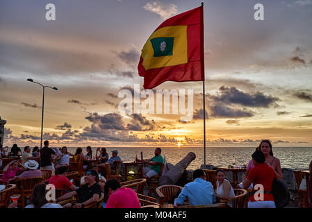 waving flag of Cartagena at sunset at Cafe del Mar Stock Photo