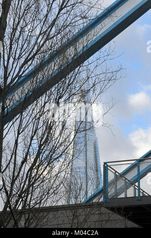 a different or unusual view of the shard office building in central London southwark. trees and tower bridge framing modern and contemporary offices. Stock Photo