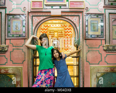 A colorful photo of two beautiful tourist sister girls enjoying at an Indian palace at Rajasthan India Stock Photo