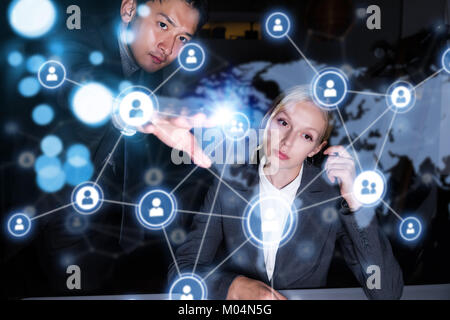 Two business persons in front of futuristic display. Social networking concept. Stock Photo