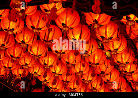 A lot of lighted Chinese paper lanterns hanging from the ceiling of a Taoist temple in Taiwan. Stock Photo