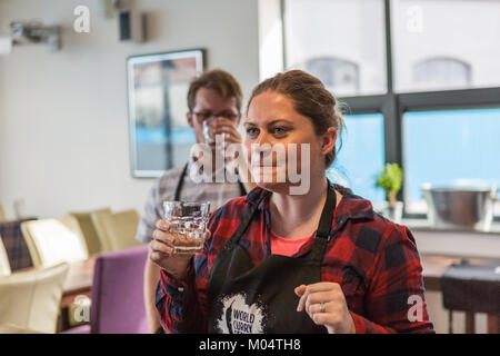 Young woman having a glass of water during cooking demonstration Stock Photo