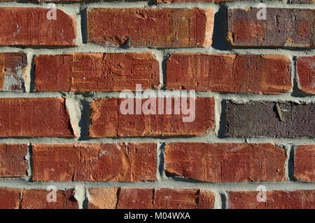 This image of a brick wall features classic masonry construction using uniform red bricks arranged in a linear pattern. The wall is a structural feature commonly found in both modern and traditional buildings, providing both stability and aesthetic appeal through its robust construction and texture. Stock Photo