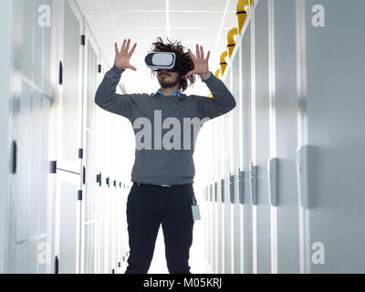 young IT engeneer using virtual reality headset over server room background Stock Photo