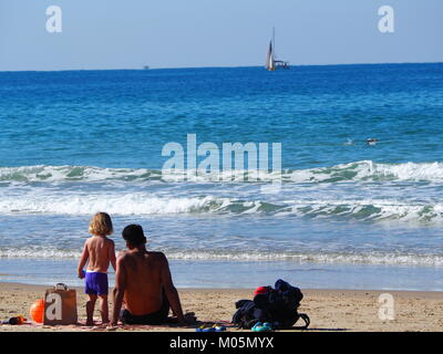 father and his son relaxing on the beach Stock Photo