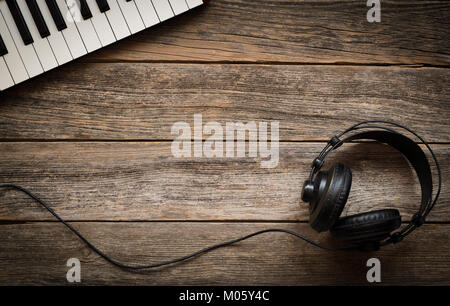 Keyboards and headphones on a wooden background Stock Photo