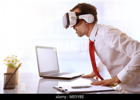 Surprised businessman using virtual reality glasses resting on his office desk. Horizontal composition. Stock Photo