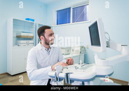 handsome doctor using an ultrasound machine Stock Photo