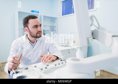 handsome doctor using an ultrasound machine Stock Photo