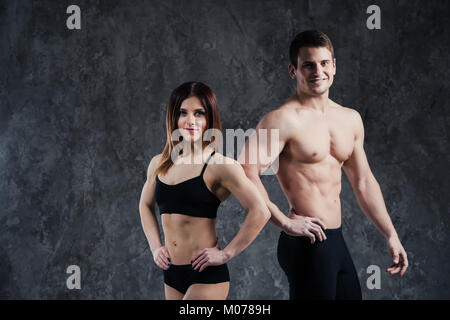 Fitness sporty healthy couple man and woman on a dark background Stock Photo