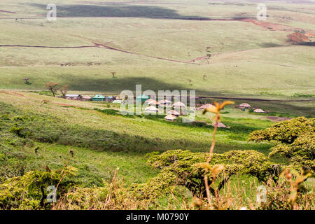 Huts village in Ngorongoro Conservation Area (NCA) protected area and a World Heritage Site located 180 km (110 mi) west of Arusha in the Crater Highl Stock Photo