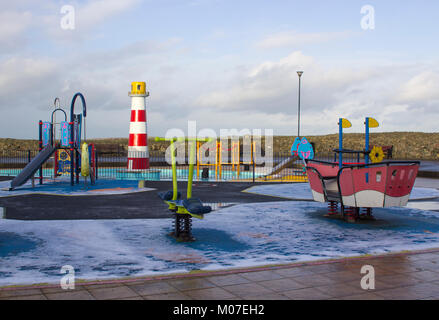 The colourful children's playground on the seafront in Donaghadee county Down in Northern Ireland in a freezing winter afternoon Stock Photo